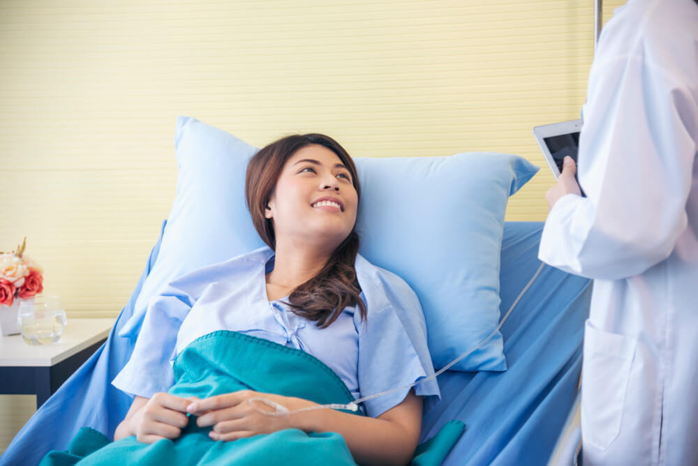 Female patient in hospital bed and doctor